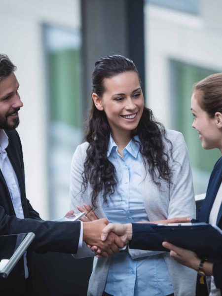 Group of businesspeople having a discussion near staircase in office